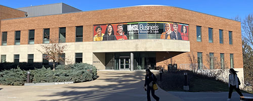 Outside of ABH hall, 2 students walking by