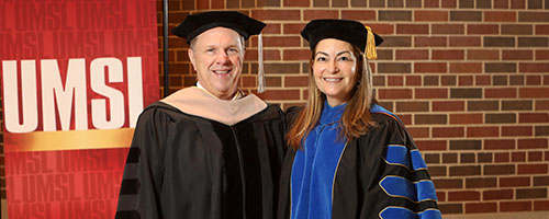 two faculty members in regalia