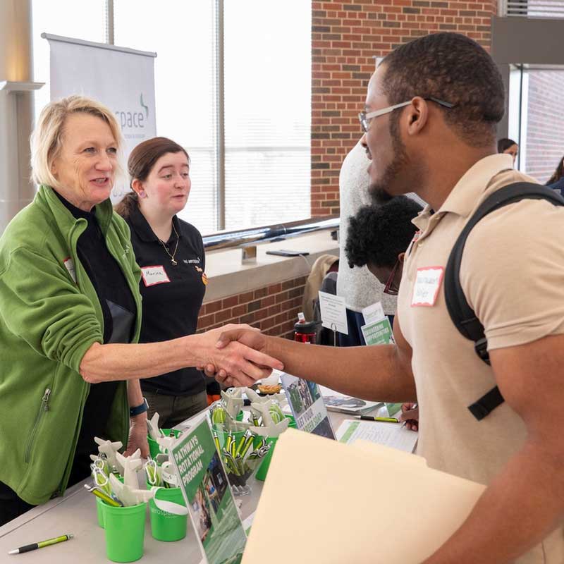 Student shaking hands at a career fair