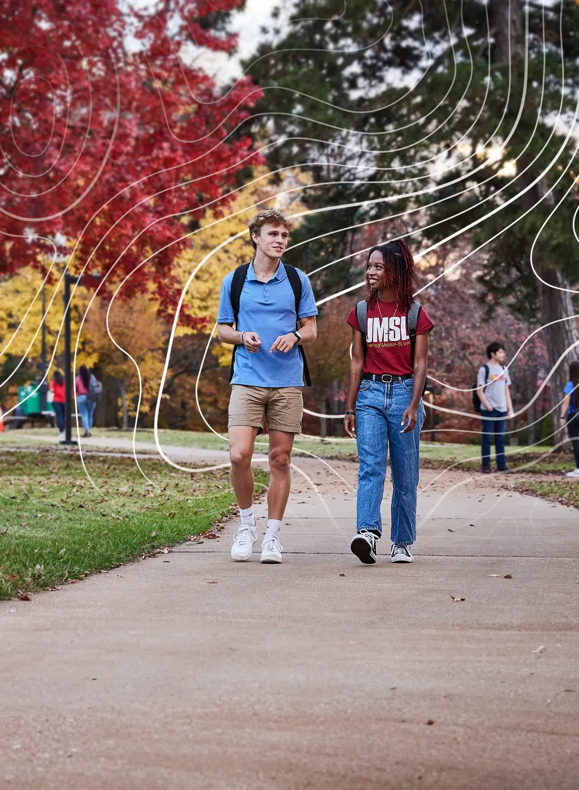 two UMSL students in conversation while walking down sidewalk