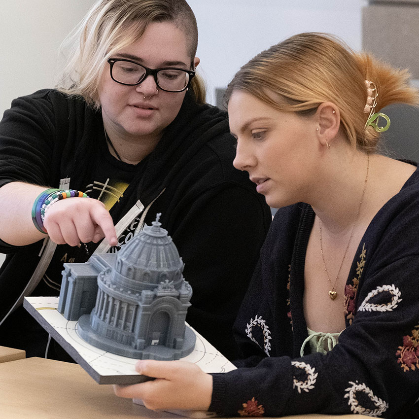 two students looking at a building model