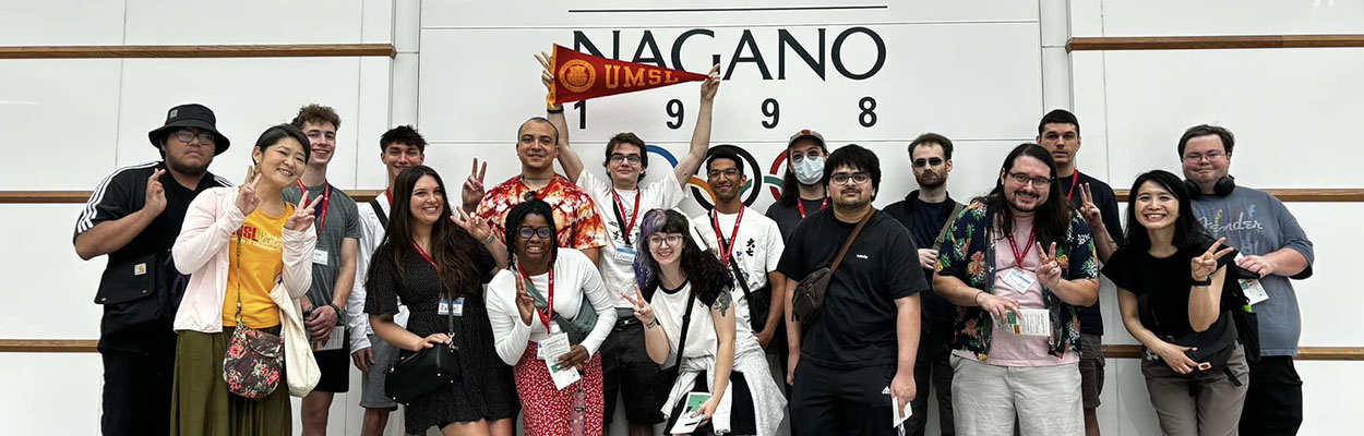 Group of students in Japan in front of a Nagano olympics sign