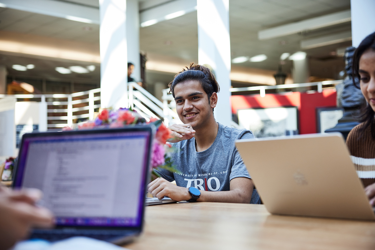 Male student at study hall with laptop