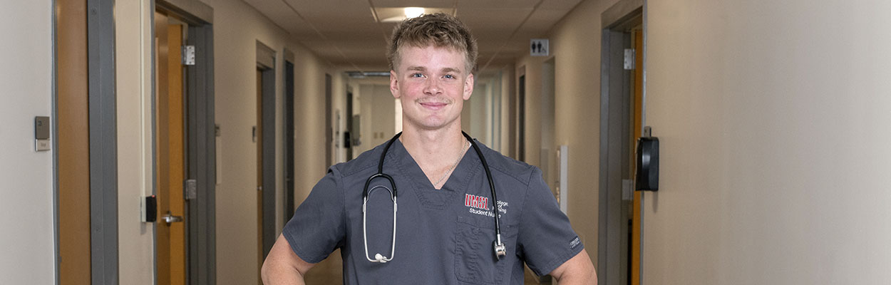 male student nurse standing in a hallway