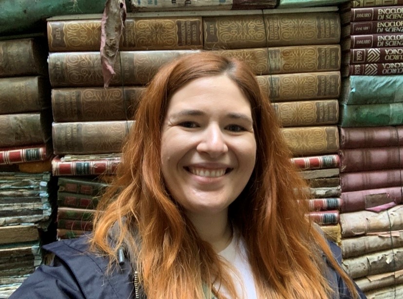 libby cozzoni standing in front of books