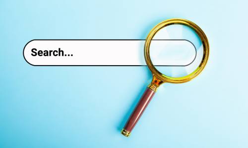 Magnifying glass focused on an internet search box.